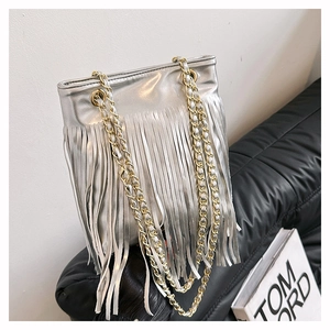 Détail d'un sac cabas argenté avec de longues franges et une bandoulière en chaîne mixte