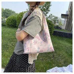 Detail of elegant floral embroidery on a vintage pink underarm bucket bag for women