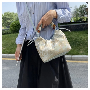 Détail de la poignée en perles et broderie florale sur un sac à main style chinois