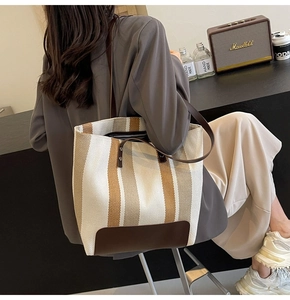 Lifestyle shot of large canvas tote bag with contrast stripes and leather handle detail