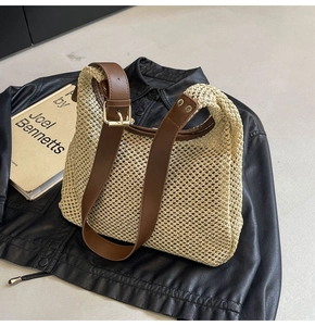 Detail of woven mesh texture with brown leather strap and gold buckle on stylish bag