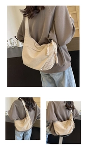 Détail du sac croissant en nylon beige avec large bandoulière et tirette en corde tressée