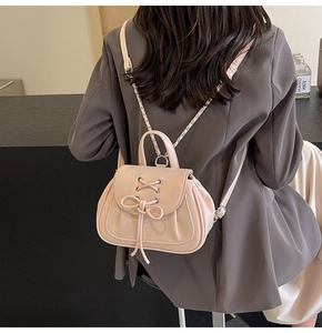 Dettaglio mini zaino stile balletto con fiocchi e spallacci a catena indossato da modella