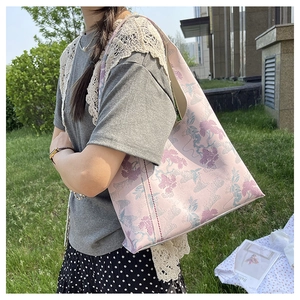 Close-up of pink tote bag with traditional Chinese pine embroidery in natural outdoor light
