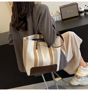 Detail of a striped canvas tote bag with leather trim and spacious commuter design