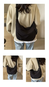 Détail d'un grand sac bandoulière croissant en nylon noir avec large sangle réglable