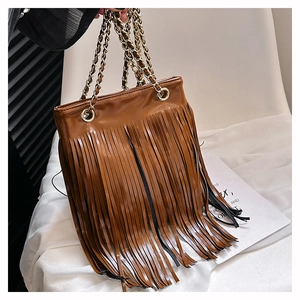 Gros plan d'un sac cabas en cuir PU marron avec de longues franges et chaînes dorées