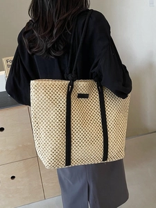 Hollow straw tote bag with black straps and large capacity for beach vacation use