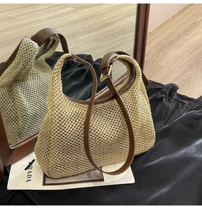 Detailed view of woven straw shoulder bag with brown leather strap and gold buckle