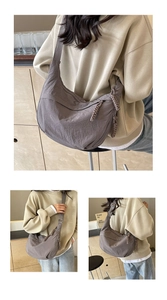 Détail du sac croissant en nylon taupe avec tirette tressée et bandoulière réglable