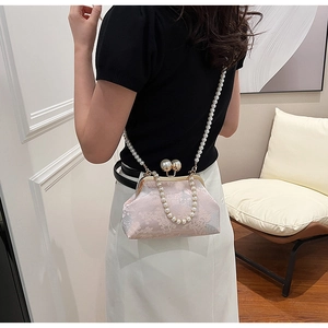 Detail of pink floral jacquard bag with pearl straps and vintage metal clasp