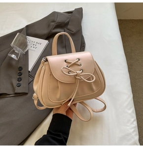 Dettaglio del mini zaino beige stile balletto con nastri intrecciati e fiocco decorativo