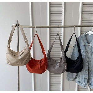 Détails de quatre sacs demi-lune en nylon avec tissu texturé et tirettes de zip tissées