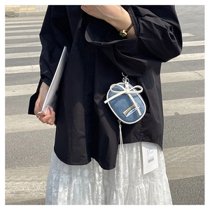 Mini bolso bandolera de mezclilla con bordado de arcoíris y lazo blanco en camisa negra