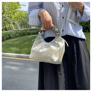 Détail d'un sac à main nuage de style chinois avec motif floral et poignée perlée