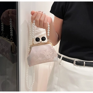 Detail of light pink embroidered Cheongsam bag with pearl chain and dual sphere clasp