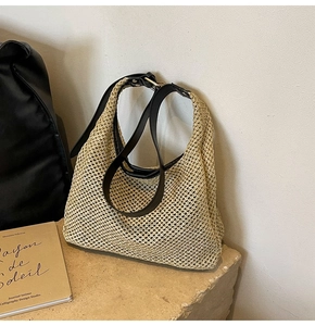 Detailed view of handmade hollow woven hobo bag with black leather shoulder strap