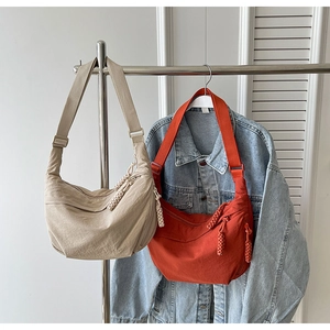 Détail de sacs croissants en nylon avec bandoulières réglables et fermetures tressées