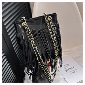 Détail du sac à bandoulière noir à franges avec des chaînes métalliques dorées élégantes