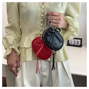 Primer plano de mini bolsos de cuero con lazos y cadenas largas en acabado plateado