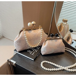 Detailed comparison of pink floral brocade kiss-lock bags with elegant pearl handles