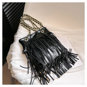 Vue détaillée du sac seau à franges noir avec bandoulière chaîne dorée et texture