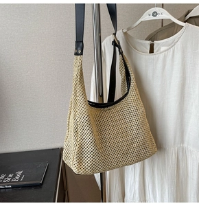Close-up of woven straw texture and adjustable black leather strap on a beige handbag