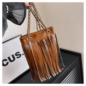 Détail du sac à bandoulière marron avec franges longues et chaînes dorées élégantes