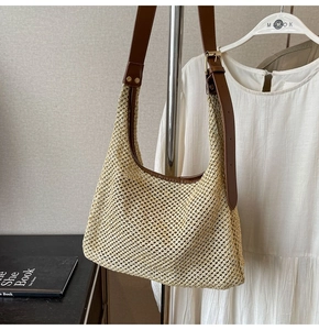 Detail of hollow woven summer shoulder bag with brown adjustable leather strap and gold buckle