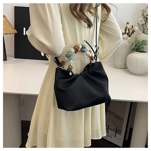 Détail du sac nuage plissé noir avec poignée en perles marbrées et bandoulière fine