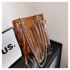 Détail d'un sac à franges marron en cuir PU brillant avec doubles bandoulières dorées