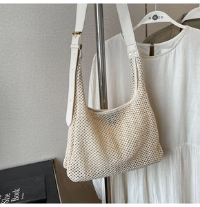 Detailed close-up of beige crochet shoulder bag with adjustable faux leather strap and gold buckle