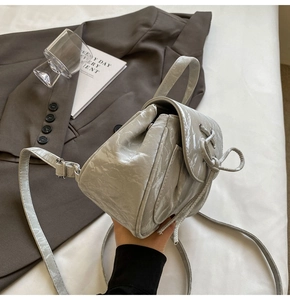Dettaglio dello zainetto grigio con trama stropicciata, coulisse e tracolla regolabile