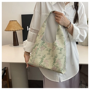 Detail of floral embroidery on a vintage beige canvas bucket bag with soft lighting