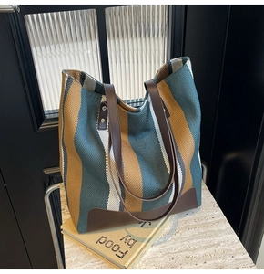 Detail of colorful knitted tote bag texture with brown leather strap and metal rivets