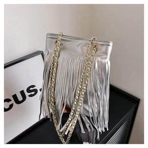 Détail du sac argenté à franges métalliques avec de longs glands et bandoulière chaîne