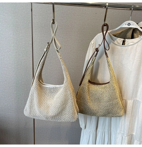 Detail view of woven shoulder bags in white and beige with premium leather straps