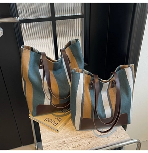 Detail of striped canvas tote bags with leather handles in large and medium sizes