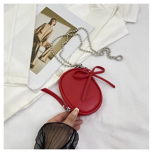 Detalle del mini bolso bandolera rojo con lazo de cuero y correa de cadena plateada