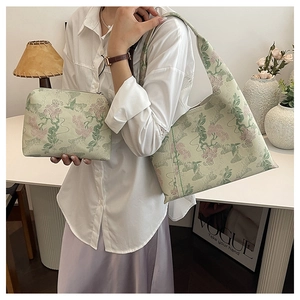 Detail of light green floral embroidered tote bag with matching zipper cosmetic pouch