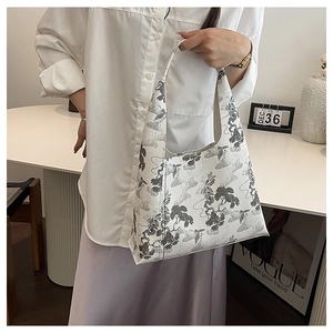 Detail of white tote bag with elegant gray landscape embroidery and stylish handle design