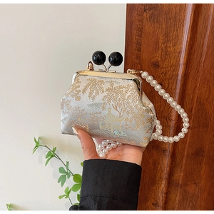 Detailed embroidery on silk bag with pearl strap and traditional landscape pattern