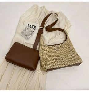 Detail of a half-moon straw shoulder bag with leather trim and matching zipper pouch