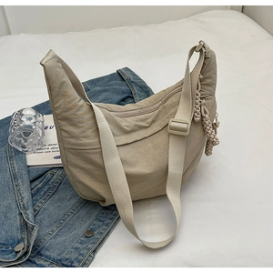 Détail du sac demi-lune en nylon kaki avec bandoulière réglable et tirette tressée