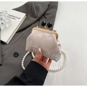 Close-up of pink jacquard qipao bag with traditional landscape pattern and pearl chain