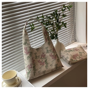 Detail of vintage floral embroidered hobo bag and matching pouch near sunlit window
