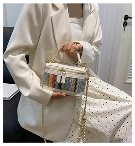 Detail view of woven mini vanity bag with chain strap styled on an elegant model