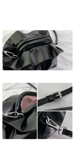 Detailed macro view of black glossy leather texture and silver metal hooks on the bag
