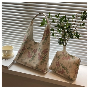 Detail view of oriental floral embroidery on cream fabric tote and pouch set