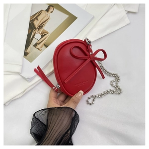 Vista detallada de un mini bolso bandolera de cuero rojo con lazo y cadena de bolas plateada
